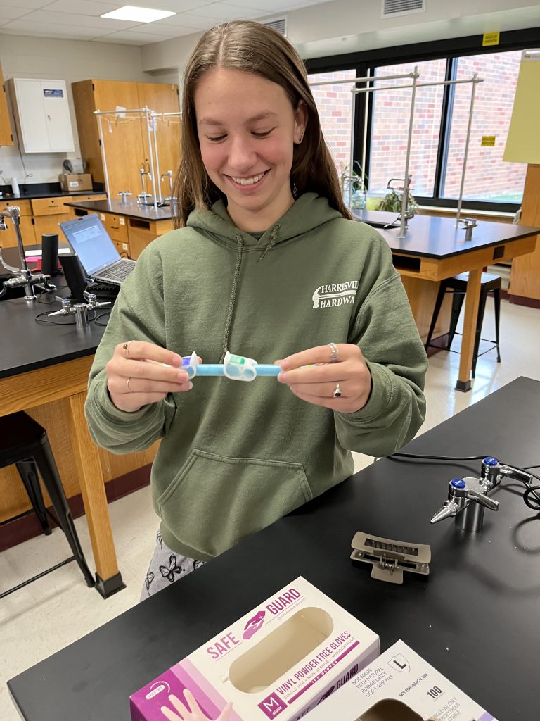 Image of girl holding science experiment tool