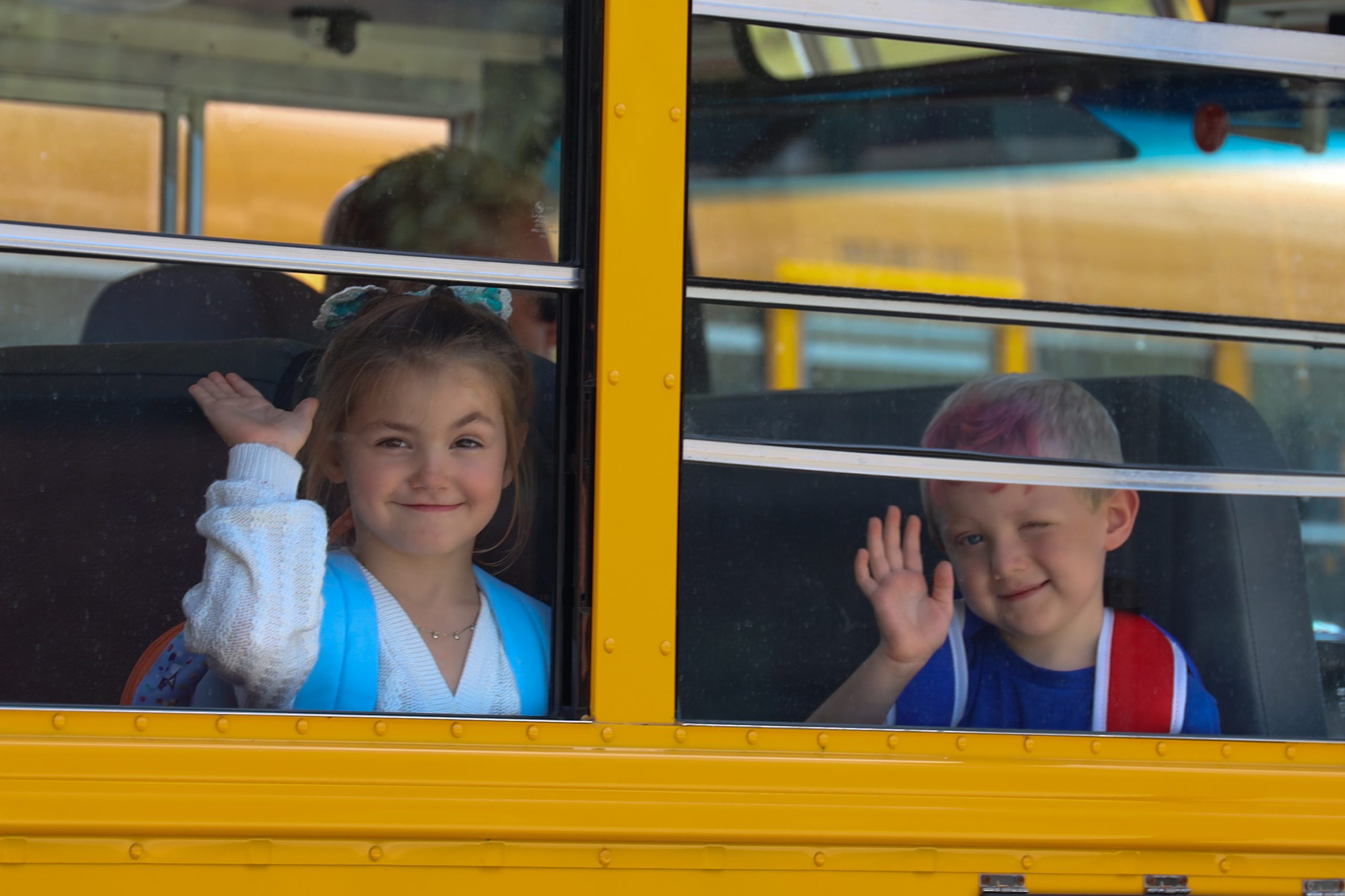 Two students on a school bus looking out the windows