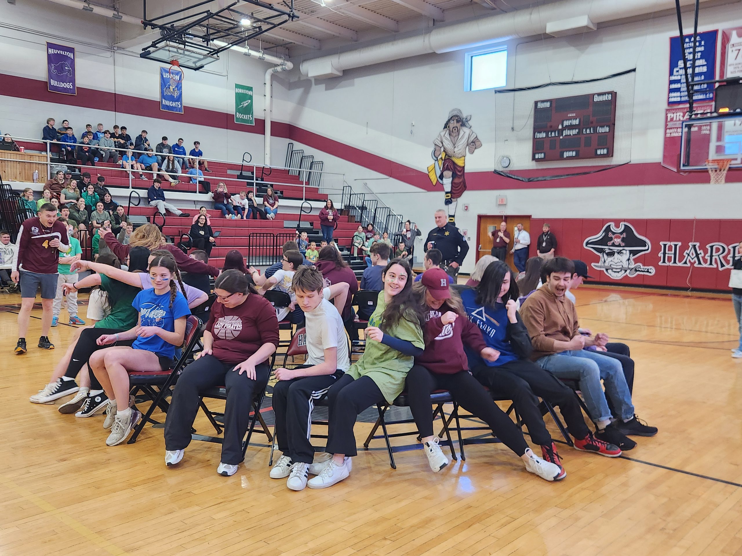 Students play musical chairs in the gymnasium.