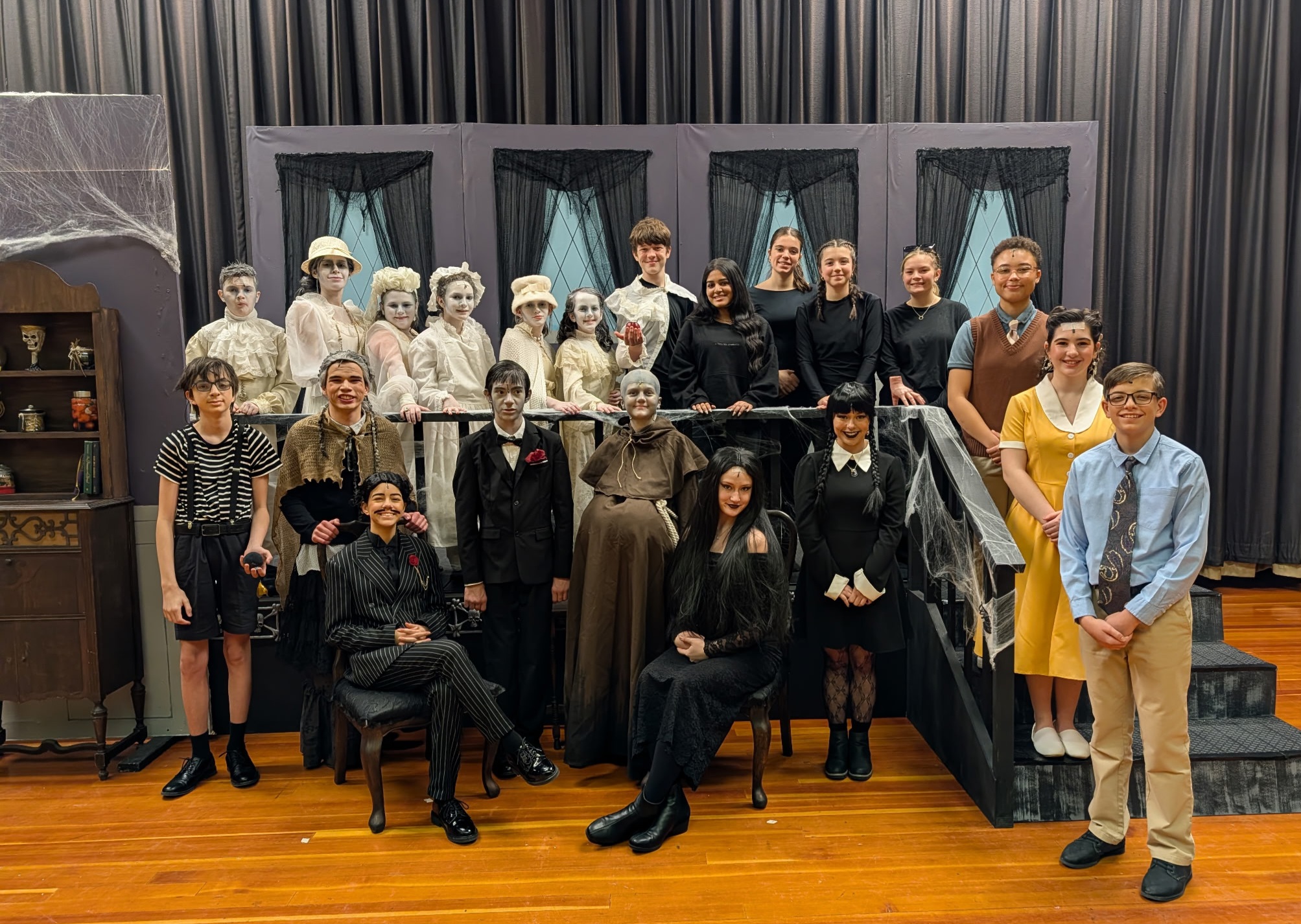 Students smile while dressed in costume for spring musical, The Addams Family.