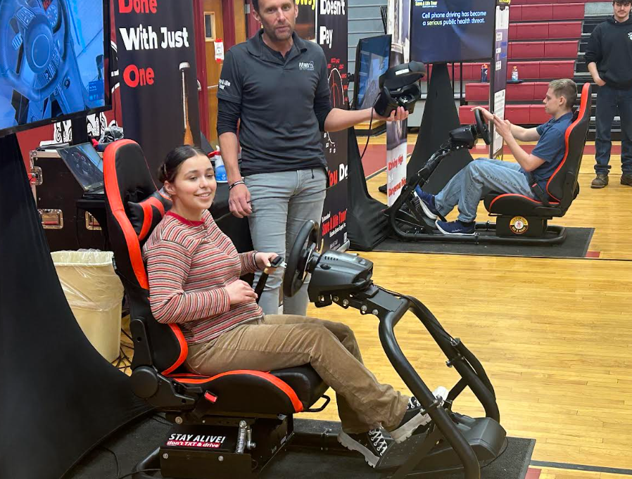 Student sits in distracted driving simulator at HCS.