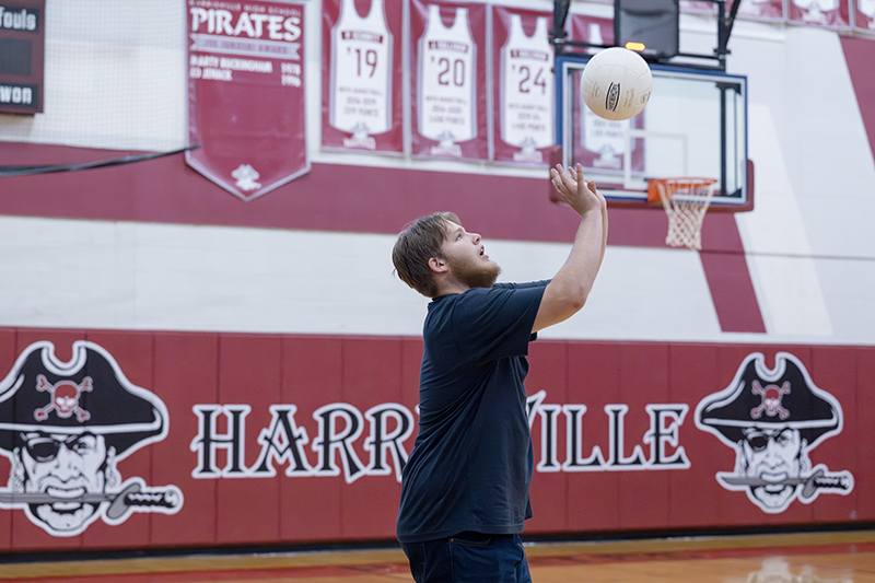 Student hits a volleyball into the air.