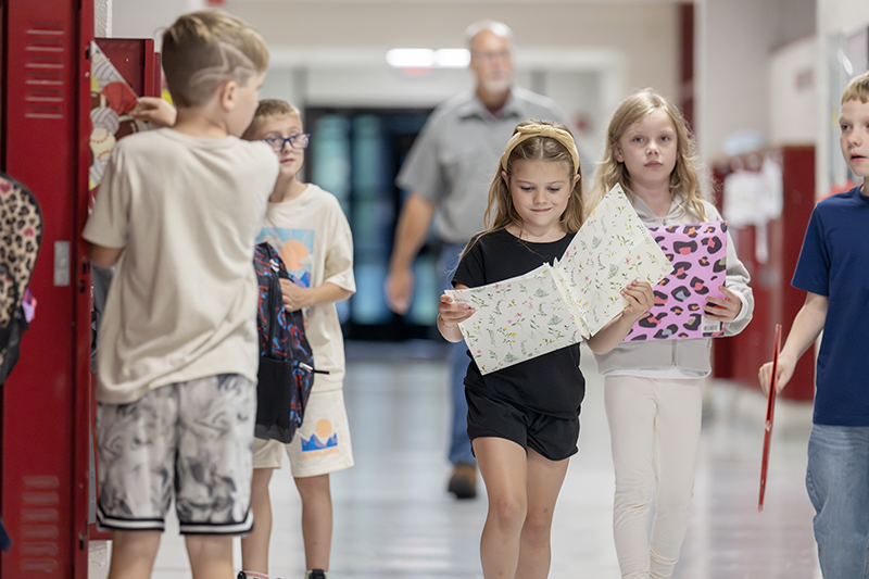 Students walk down a hallway.